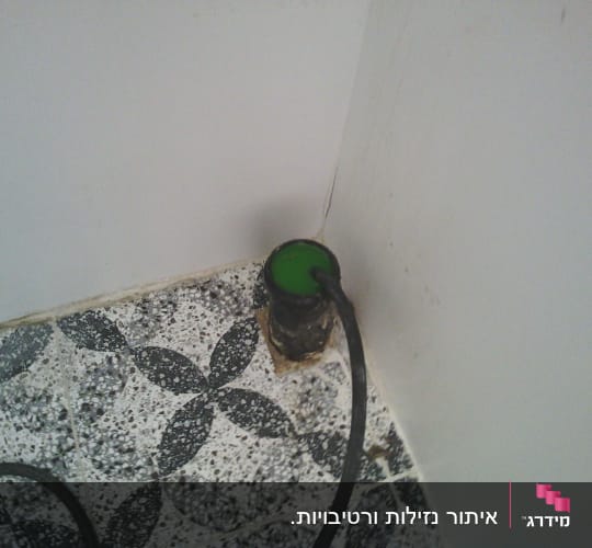 צינור עם נוזל ירוק על רצפה מעוטרת